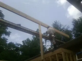 Carpenter setting a ridge beam over a new addition frame — Ice Dam Removal by Roofing Brothers in Pennsboro