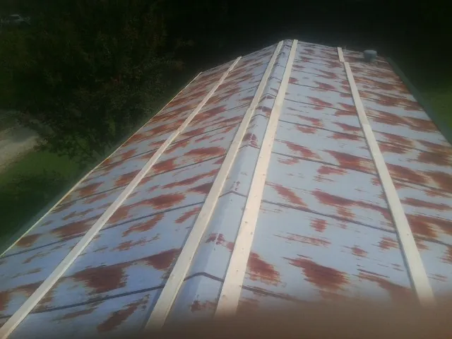 Rusted metal roof panels with new wood purlins before replacement — Storm Damage Roof Repair in Pennsboro by Roofing Brothers