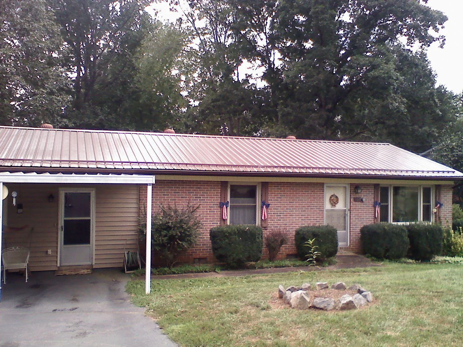 Bronze metal roof and carport on a brick ranch home — Roof Repair work by our crew in Pennsboro